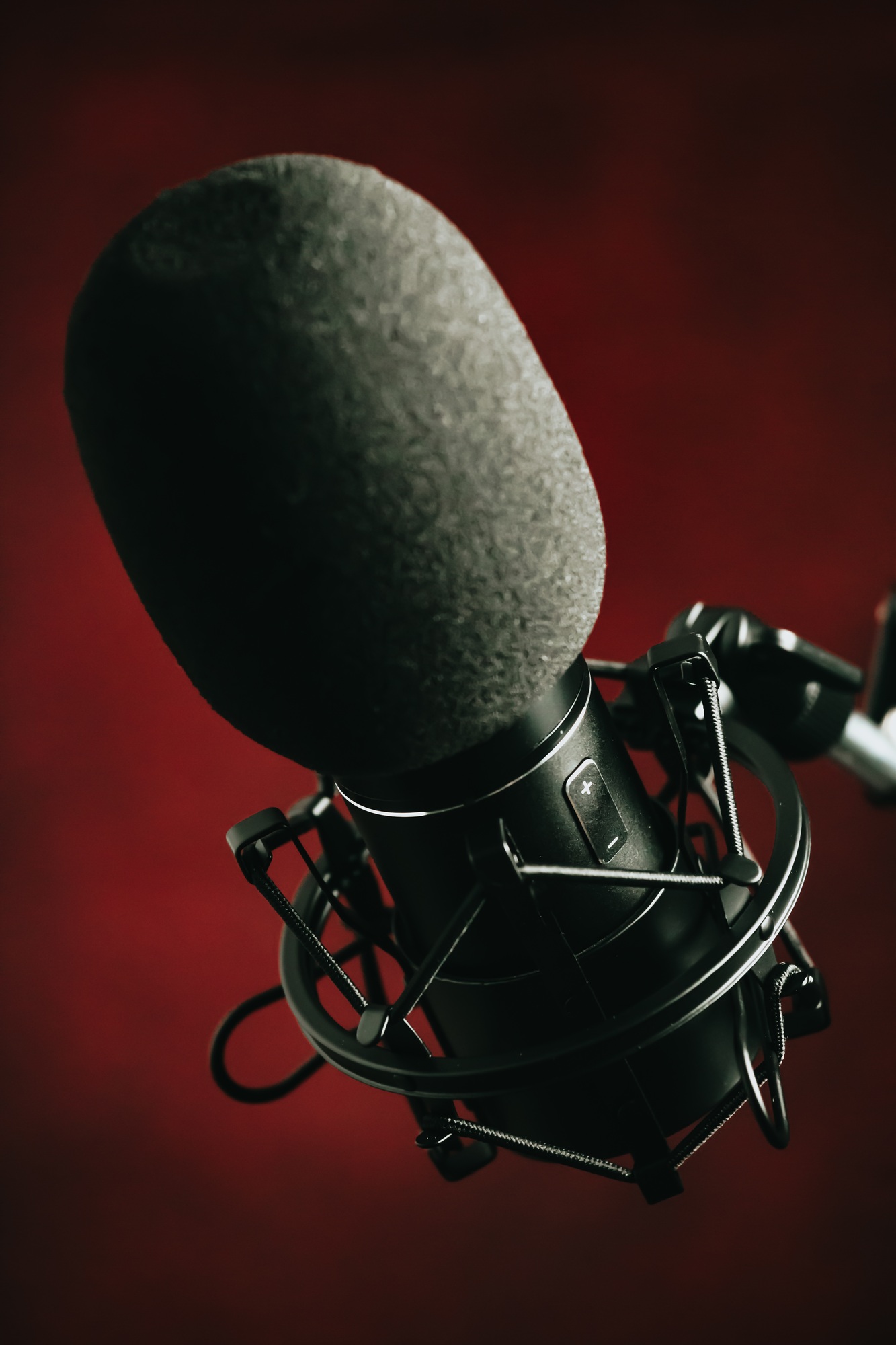 A close up of a streaming microphone over a red background with copy space